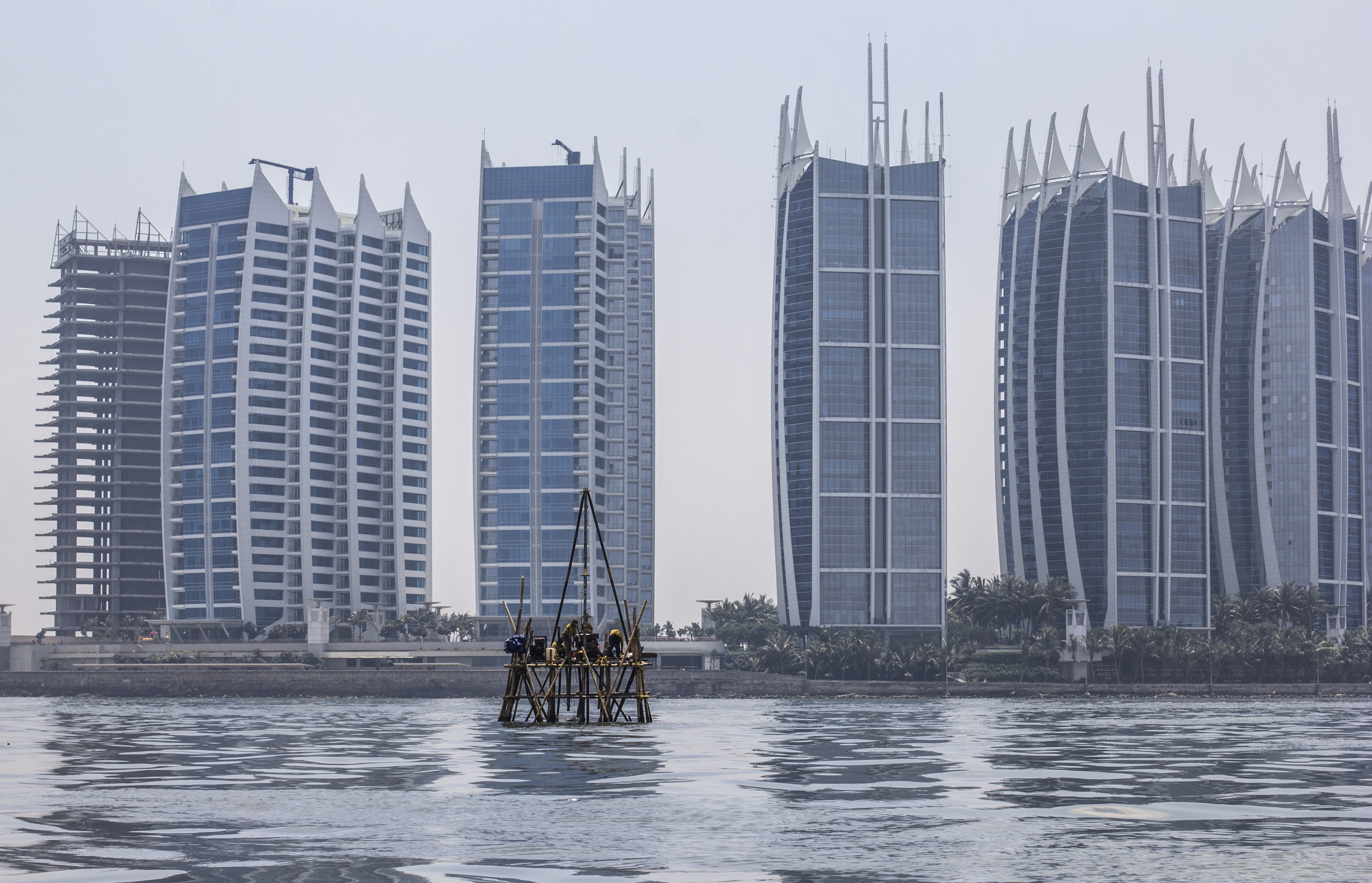  Image of Workers on a bamboo platform take sea floor measurements of Jakarta Bay in front of the massive Regata Development Complex in North Jakarta